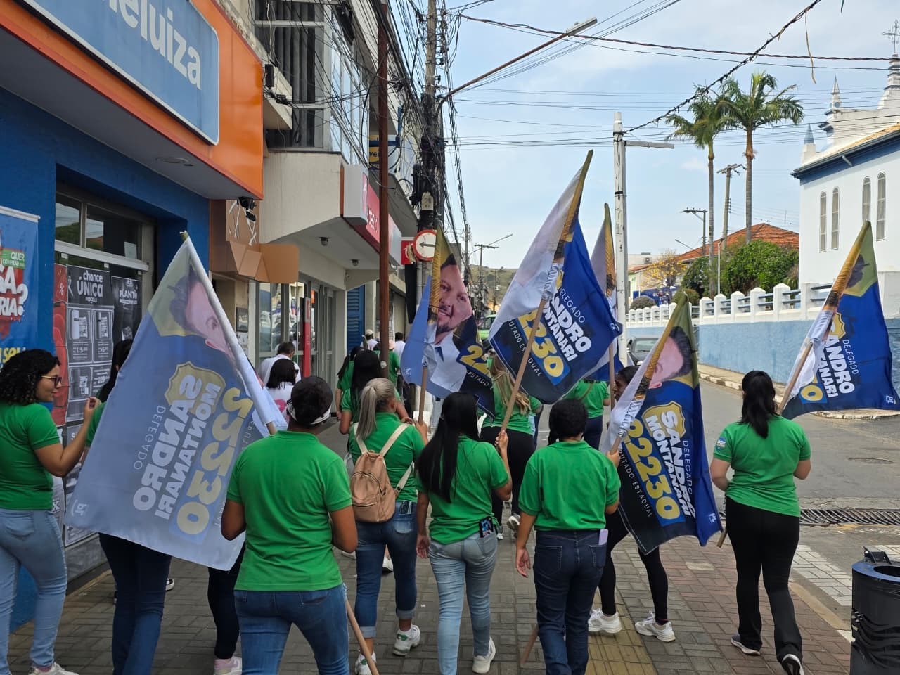 Vários colaboradores uniformizados com bandeiras caminhando